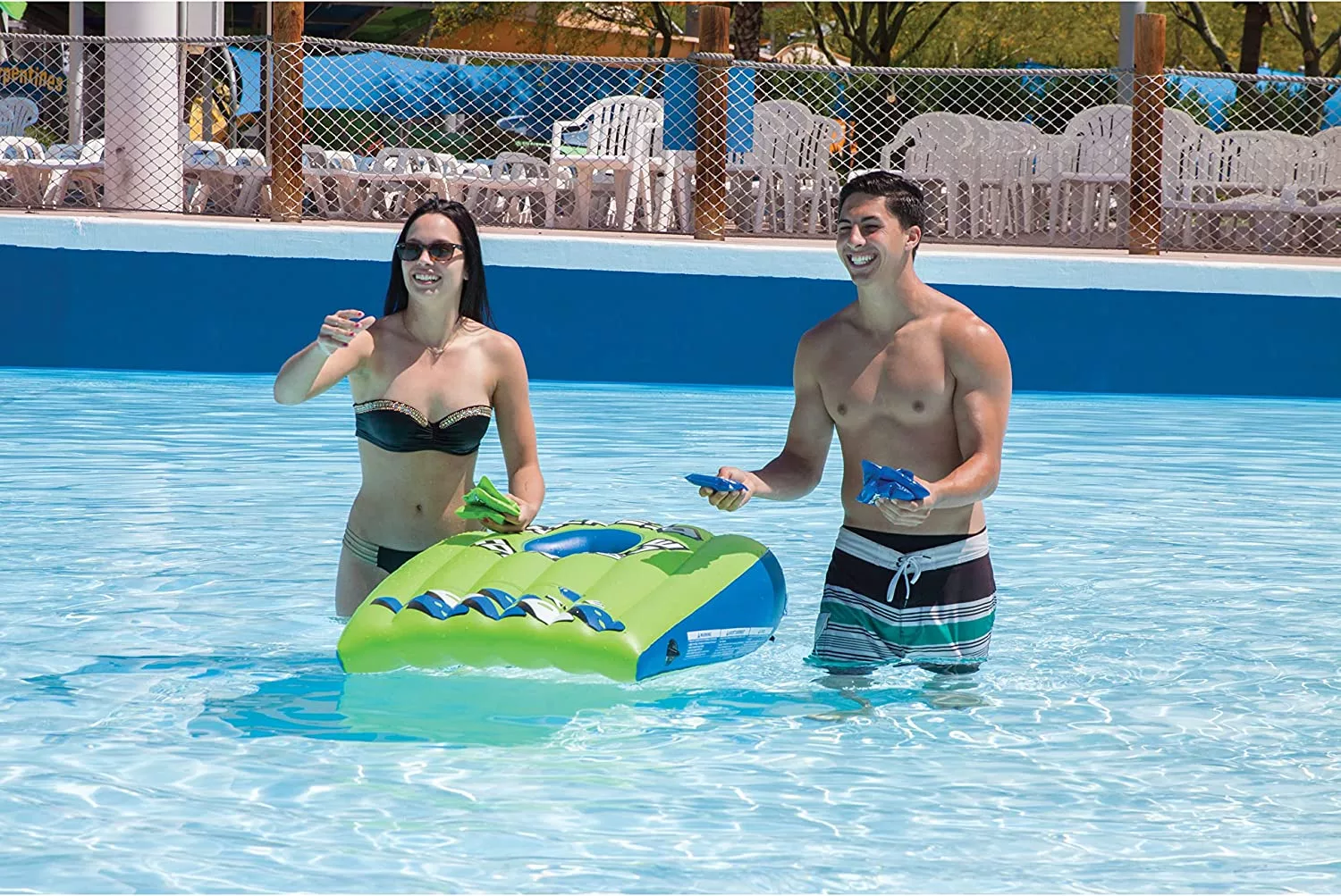 Man and Woman Playing with Floating Cornhold Set in Pool