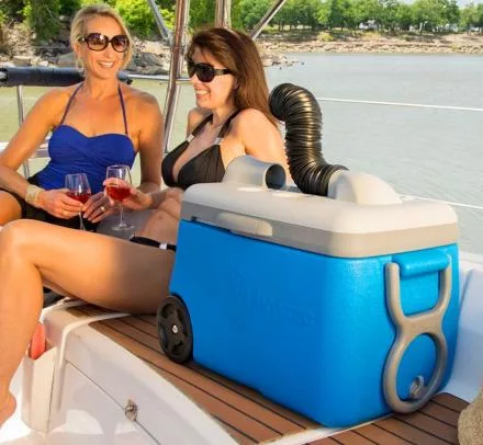 Two women on a boat with IcyBreeze Portable Air Conditioner and Cooler