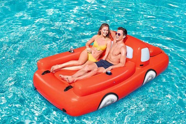 Couple floating on the back of the Pickup Truck Pool Float With A Cooler Under The Hood