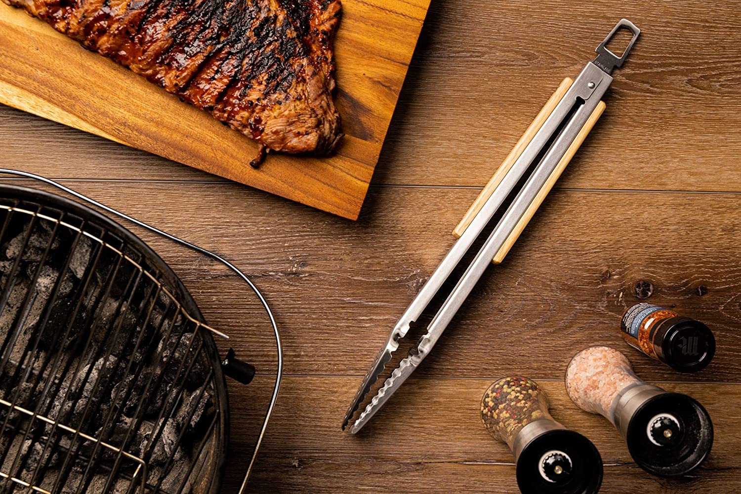 GRILLHOGS 16-Inch Barbecue Tongs Sitting on table next to meat and grill