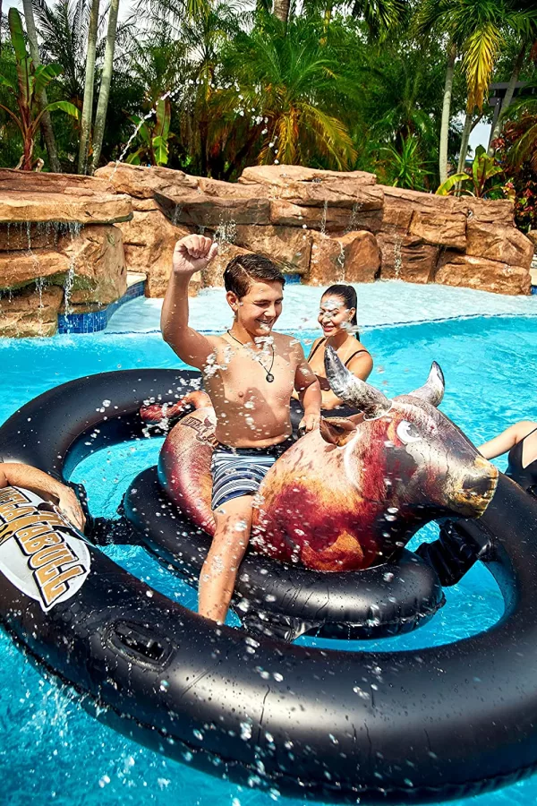 Young Guy on the Inflatable Bull Riding Pool Toy