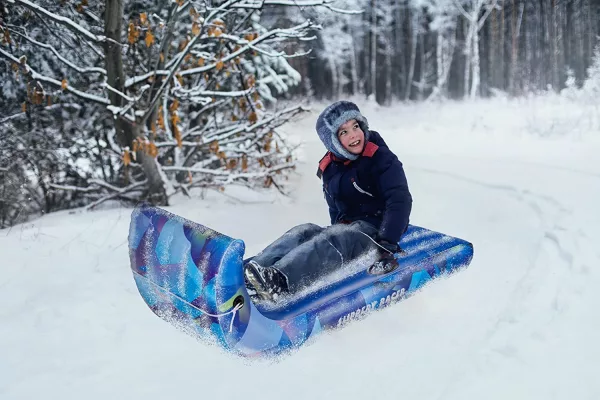 Young boy riding on the Flexible Toboggan Sled